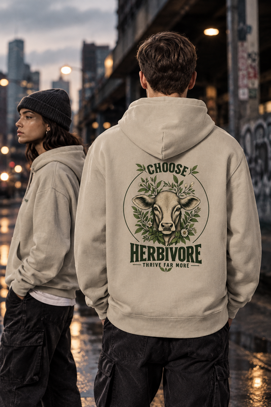 männliches Model mit dem Rücken zum Betrachter in einer urbanen Scene trägt einen hellbeigen Kapuzenpulli mit dem print choose herbivore, thrive far more. Daneben ein weibliches Model in abgewandter Richtung blickend.