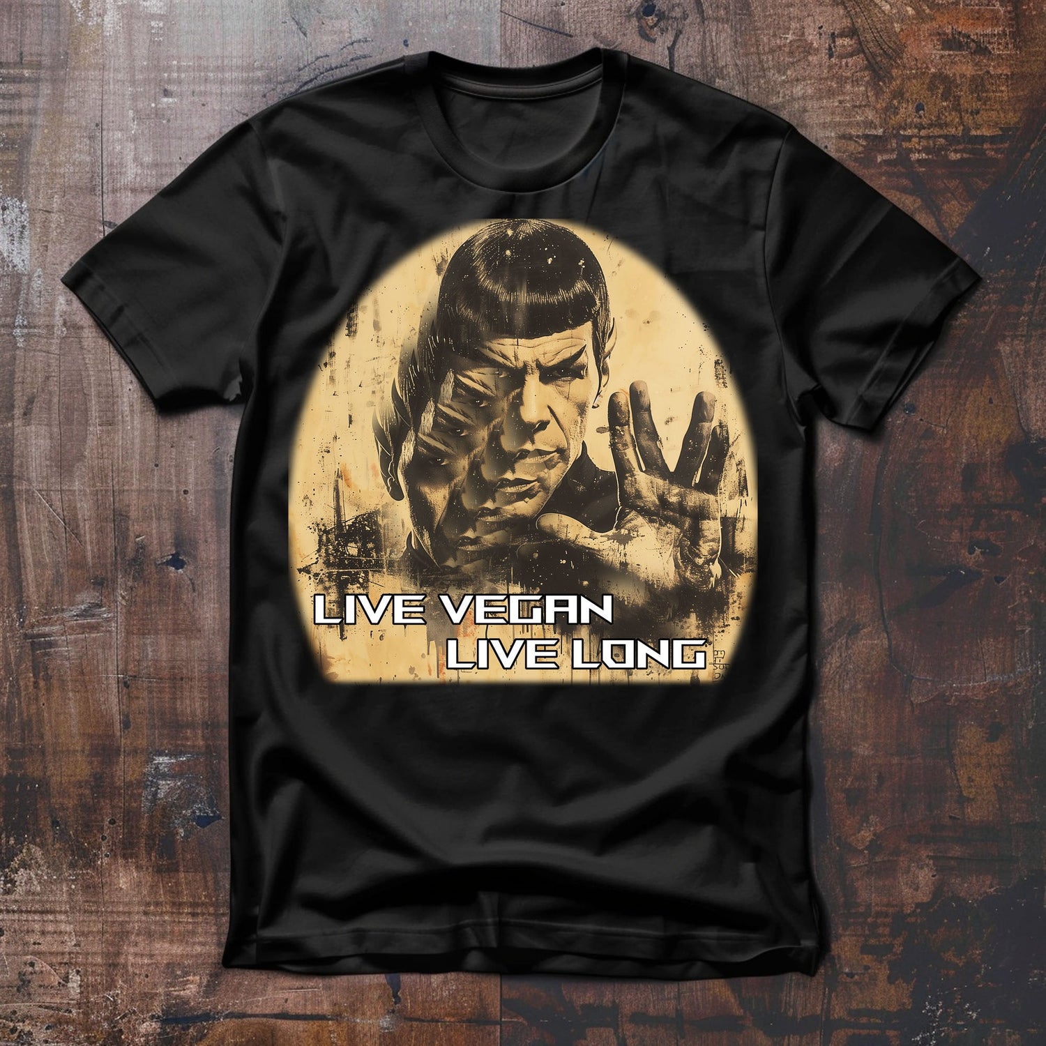 Silhouette von einem ernst blickenden Männerkopf mit ausgestreckter Hand, die den v-förmigen Vulkanier Gruß zeigt. Der Slogan lautet "live vegan, live long"